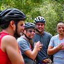 Diverse group of cyclists gathered at a community cycling event, laughing and conversing.